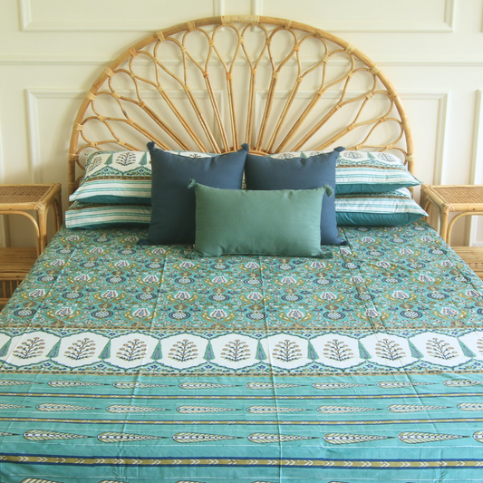 Teal patterned bedsheet with repeating floral motifs, cream panels, and blue striped border