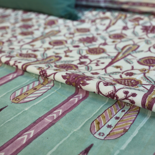 Dohar blanket with mauve, teal, and cream patterned fabric; decorative motifs on fold