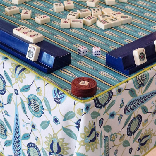 Mahjong mat with teal playing surface, blue rails, and patterned border cloth