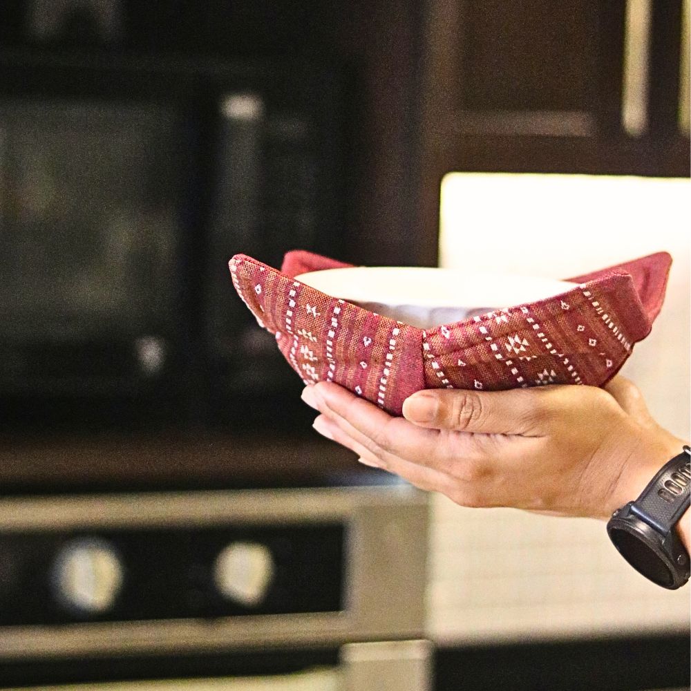 Reversible pot holder bowl style in ruby red, used to hold a dish from oven