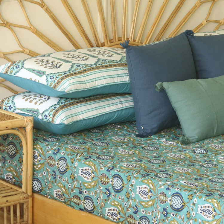 Teal bedsheet with floral medallion blocks, blue trim, and horizontal striped border