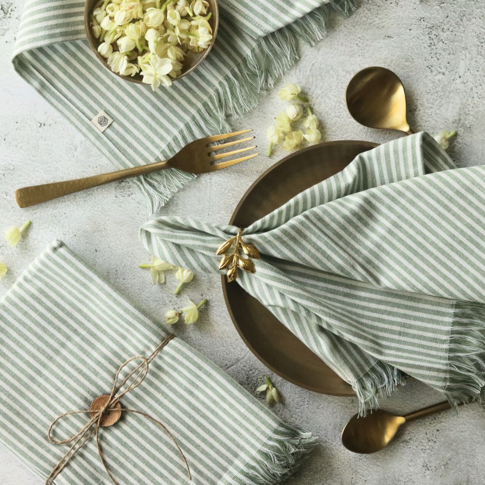 Sage green striped cotton table napkin with fringed edges, tied bow fold