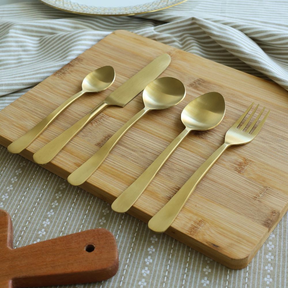 Matte gold cutlery set with three spoons, a knife, and a fork