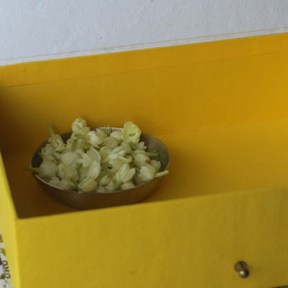 Yellow hamper gift box interior with a bowl of pale flowers inside