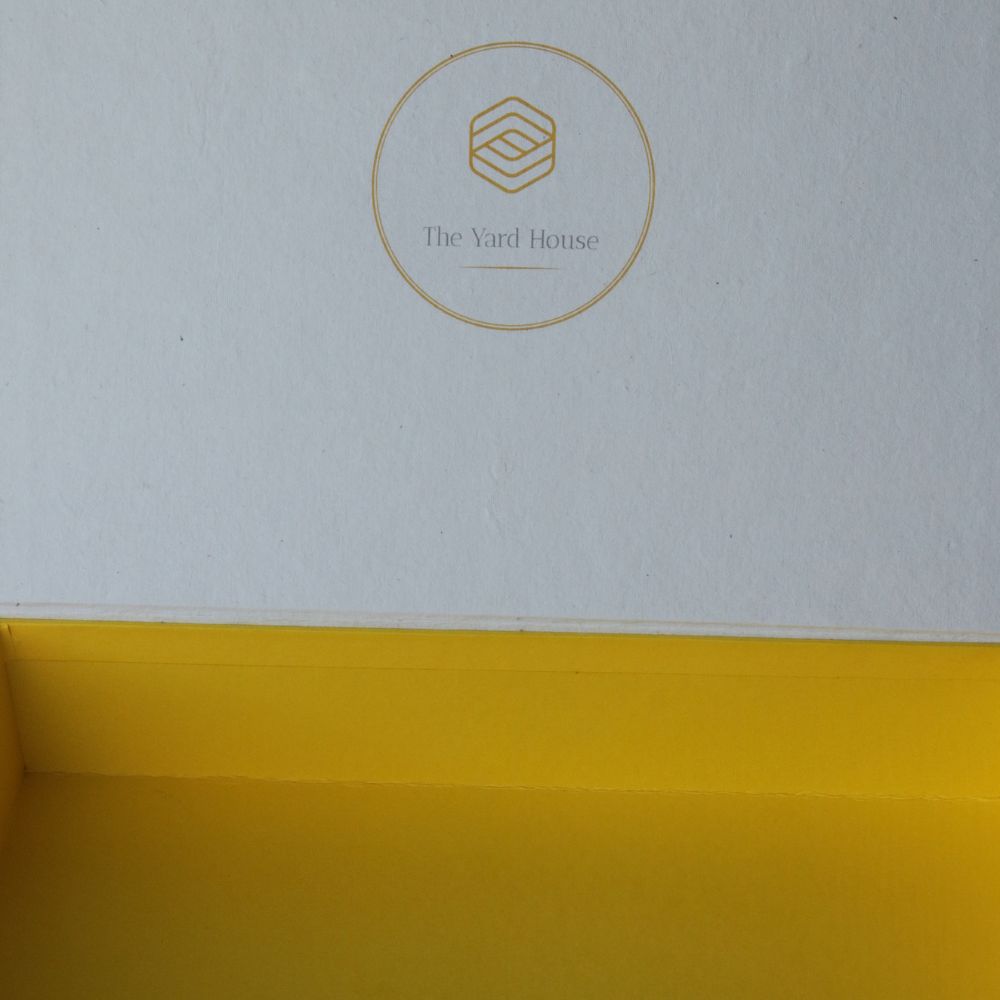 Yellow hamper gift box with circular logo stamp on inner panel