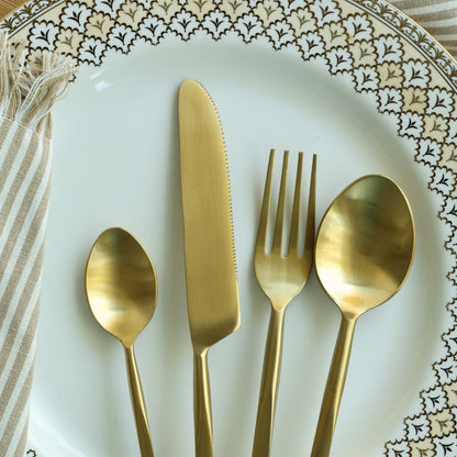 Matte gold cutlery set with dinner knife, fork, tablespoon, and teaspoon