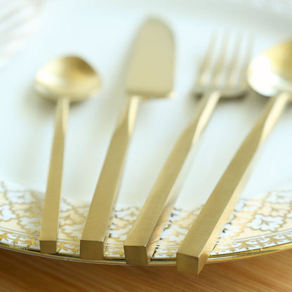 Matte gold cutlery set viewed close up, showing the flat-ended handles