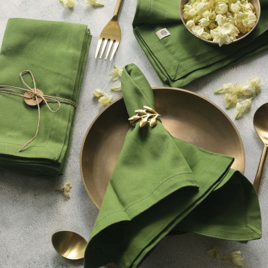 Green cotton napkins, folded stack with stitched borders and ribbon-tie accent