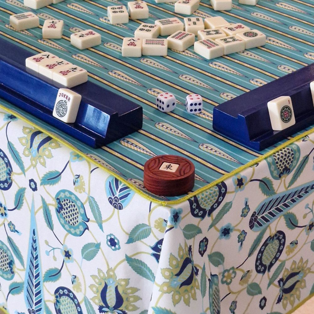 Mahjong mat with teal playing surface, blue rails, and patterned border cloth