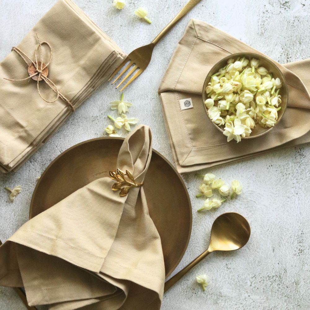 Set of beige cotton table napkins with gold leaf bow ties