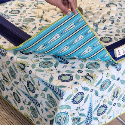 Mahjong mat corner with teal center bands, blue rails, and botanical print edge