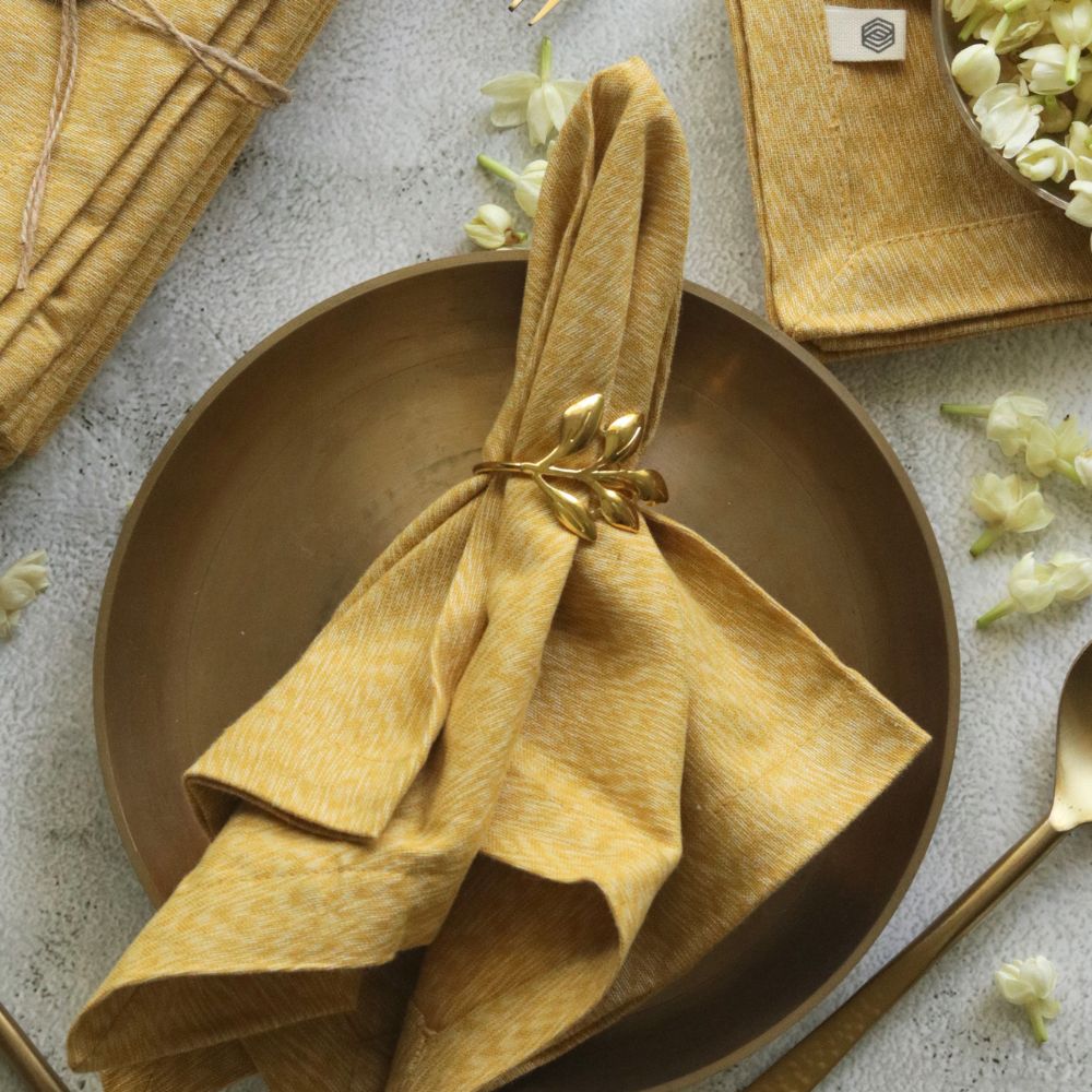 Mustard yellow cotton napkin, fan-folded with tied bow centerpiece