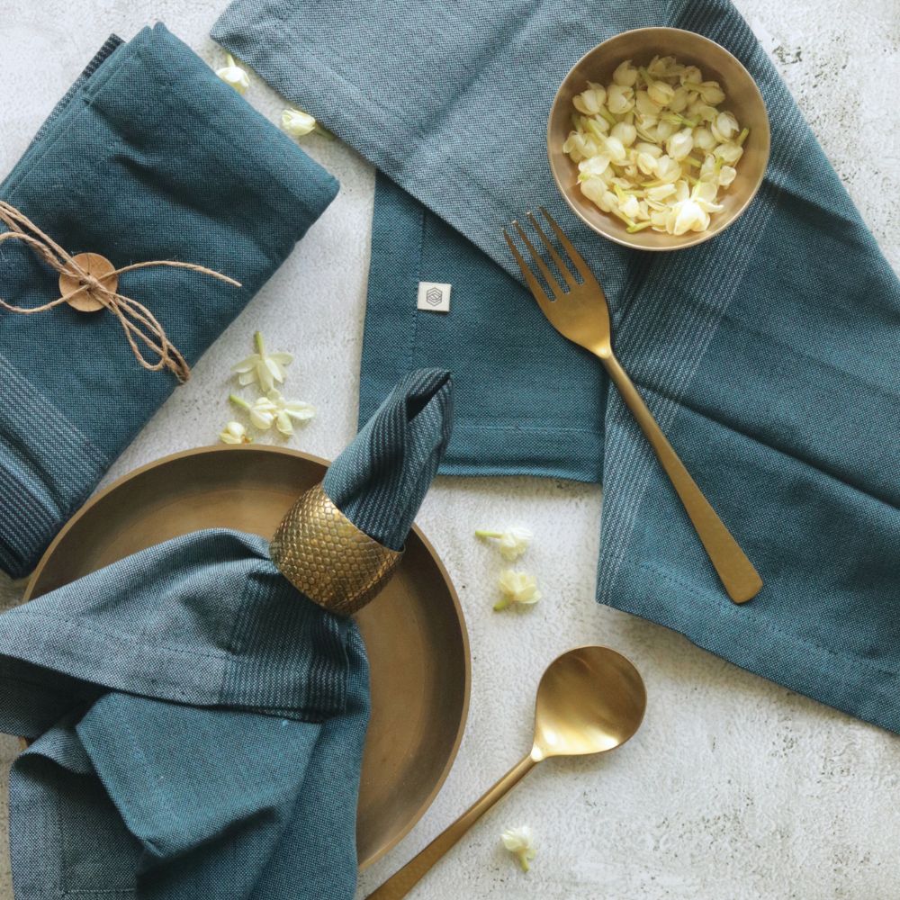 Aegean blue cotton table napkin, neatly folded with tied fabric and tag