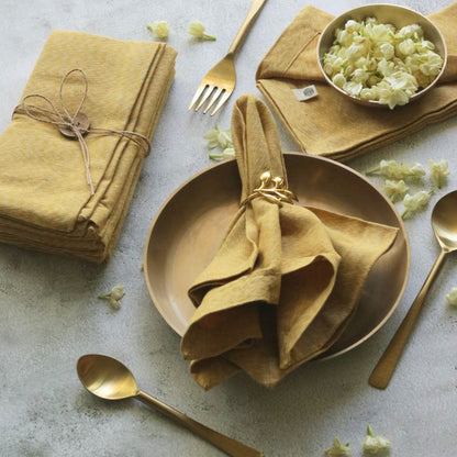 Mustard yellow cotton napkins, stacked and folded with bow ties