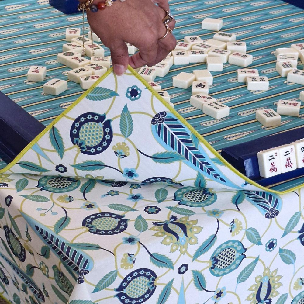Mahjong mat with blue-and-teal floral border cloth and yellow rope trim detail