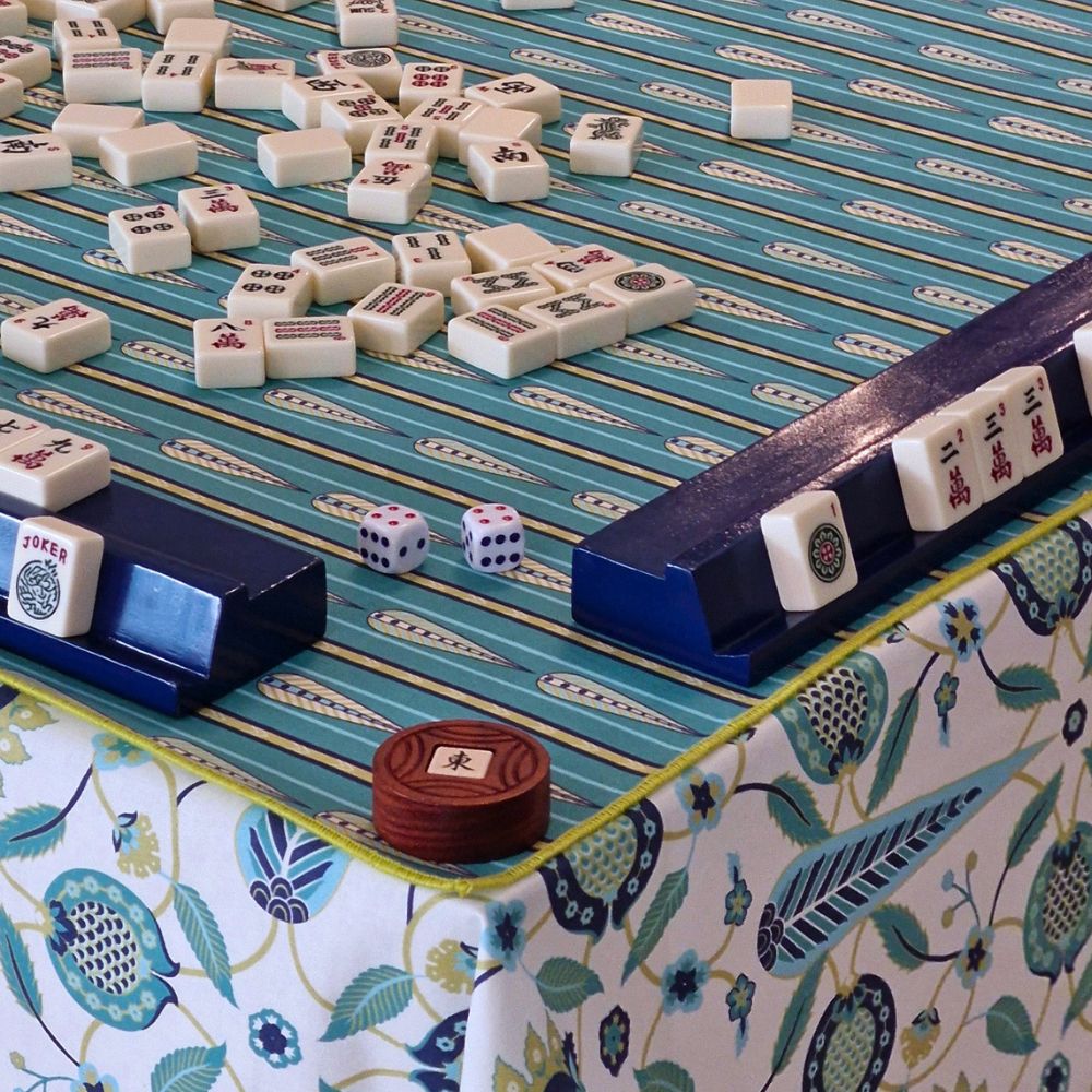 Mahjong mat with teal surface, dark blue end rails, and botanical border print