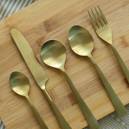 Five matte gold utensils: three spoons, a knife, and a fork