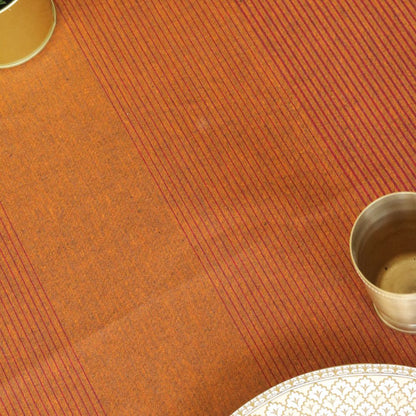 Close-up of a textured orange surface with a metallic cup on the right.