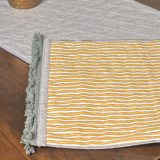 Close-up of an ochre and white striped 4 seater reversible runner edge with grey fringed tassels.