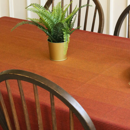Dining table with a red tablecloth and a potted plant on it