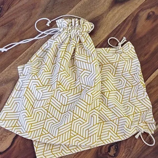Elegant 10"x10" drawstring gift pouch by The Yard House in signature print, perfect for coasters and trivets, beige color.