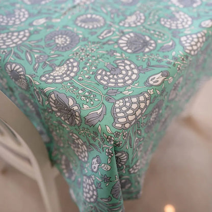 Tranquil Teal Tablecloth by The Yard House, featuring bold floral designs, available in 60” round, square, or 48”x72” rect...