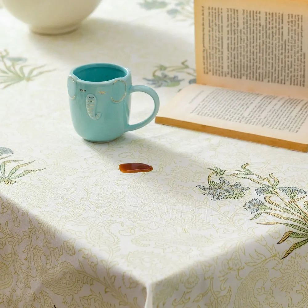 Whispering Willow Tablecloth by The Yard House in green and pale yellow, 60” square, featuring minimalist floral designs.